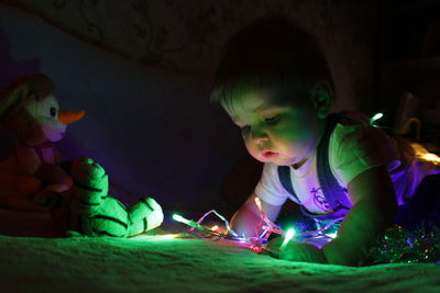 Close-up of baby boy playing with illuminated string light