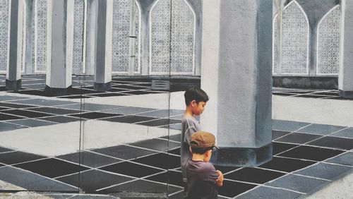 Boys standing against painted walls