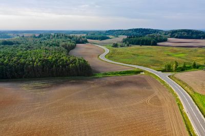 Scenic view of road amidst field against sky