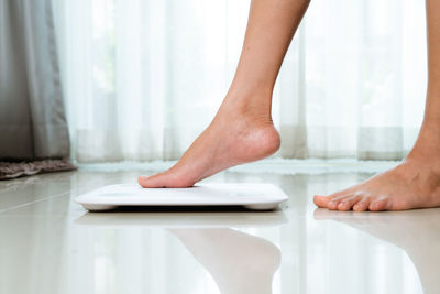 Low section of woman standing on table