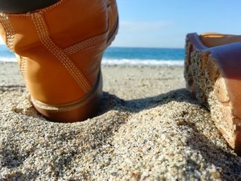 Low section of shoes on beach