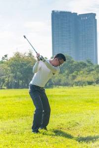 Rear view of man playing at golf course