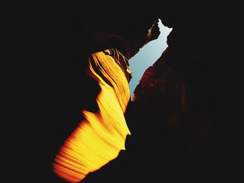 Close-up of silhouette rock formation against sky at night