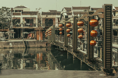 Illuminated lanterns hanging by buildings in city