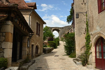 Alley amidst old buildings against sky