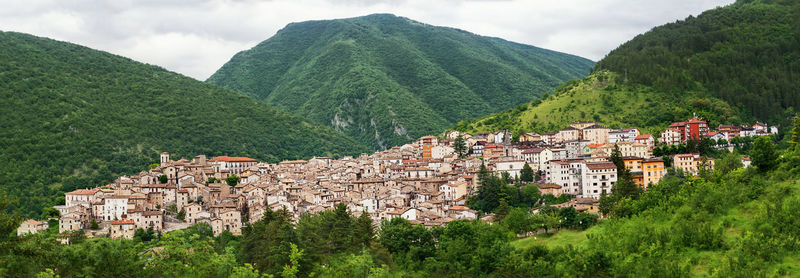 Panoramic shot of townscape by mountain against sky