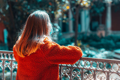 Rear view of woman standing by railing