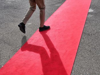 Low section of man walking on red carpet