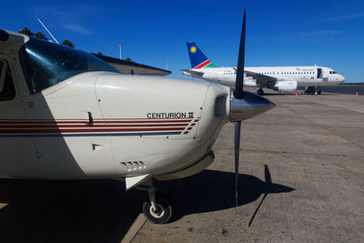 Airplane on airport runway against sky