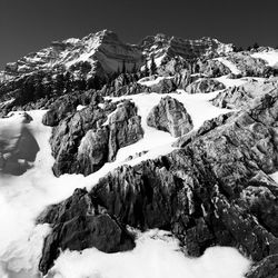 Snow covered rocks against mountain