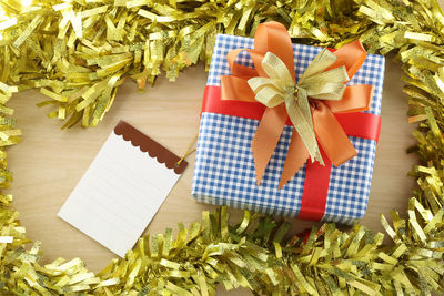 Directly above shot of christmas present and picture frame on wooden table