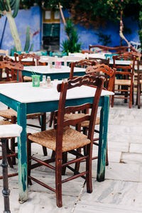 Empty chairs and tables at sidewalk cafe