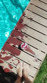 Low section of person standing by swimming pool