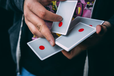 Midsection of person holding playing cards
