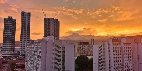 Modern buildings against sky during sunset