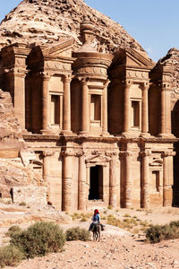 People riding horse in front of historical building