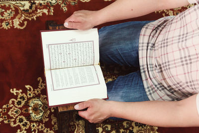 Midsection of man reading spiritual book