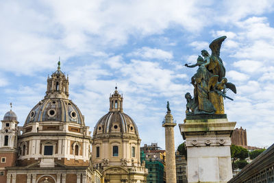 Statues of building against cloudy sky