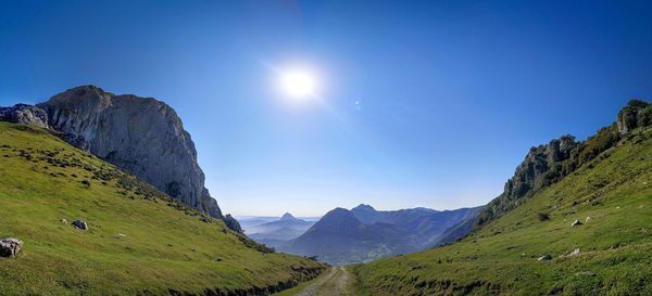 Scenic view of mountains against blue sky