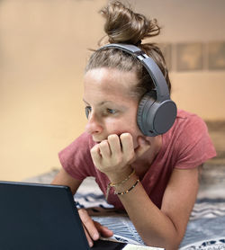 Woman listening music while using laptop