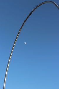 Low angle view of moon against clear blue sky