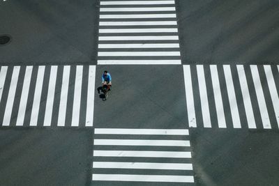 Rear view of woman crossing bicycle on street