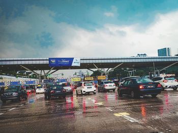 Cars on road against sky in city