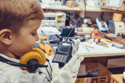 Portrait of boy with mobile phone on table