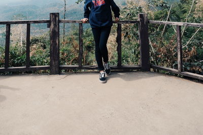 Low section of man walking on railing