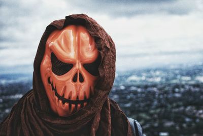 Close-up of human face against stone wall during halloween