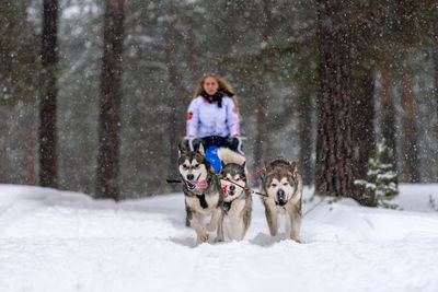 Portrait of woman with dog in snow