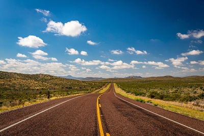 Road passing through landscape against sky