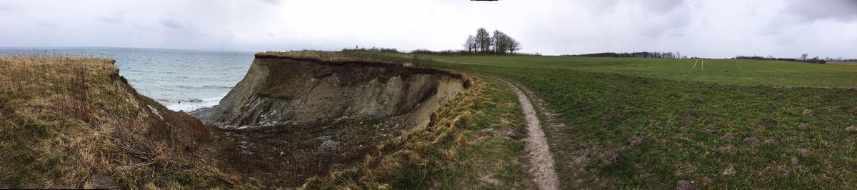 Panoramic shot of road by sea against sky