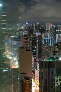 Illuminated buildings in city against sky at night