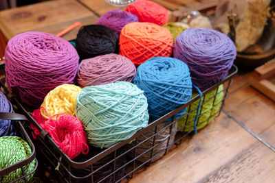 Close-up of multi colored wool in basket on table