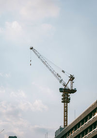 Low angle view of crane against sky