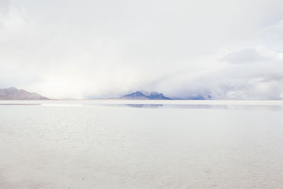 Salt flats against sky during foggy weather