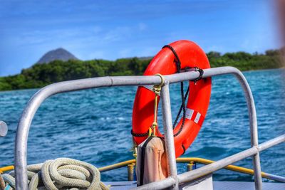 Close-up of rope tied to railing against sea