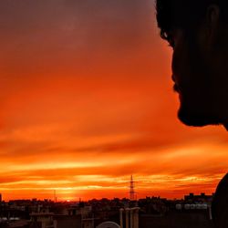 Portrait of silhouette city against orange sky