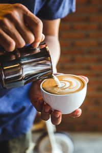 Midsection of man holding coffee cup