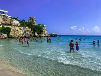 People at beach against sky