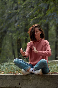 Young woman sitting on bench in park