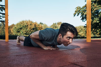 Young man lying on floor against sky