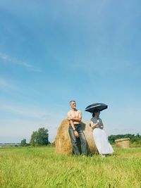 Couple on field against sky