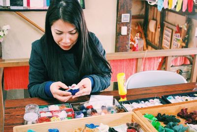 Woman holding craft product at shop for sale