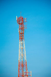 Low angle view of communications tower against clear blue sky