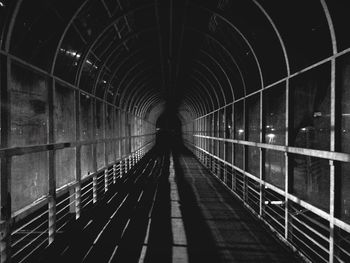 Man on illuminated bridge at night