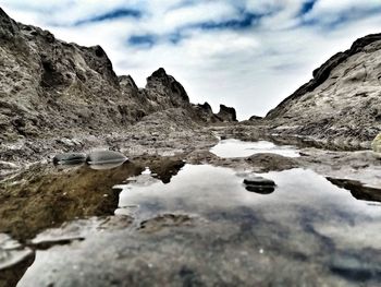 Surface level of rocks in lake against sky