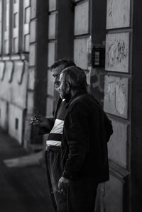 Side view of man standing on street in city