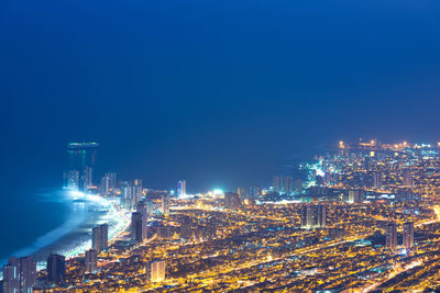 Aerial view of illuminated buildings against clear sky at night